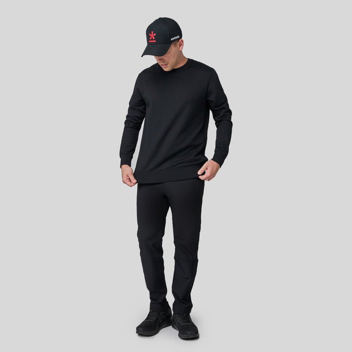 Full-body shot of Berto wearing the black swartshirt on a light gray background